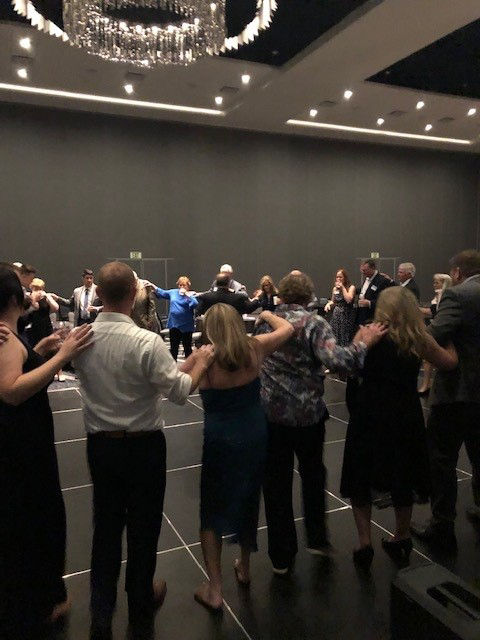 Citation Celebration Dinner attendees lined up with their right hands on the shoulder of the person in front of them.